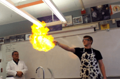 Levi W. - UC Davis Engineering wearing an apron and lighting a ball of gas on fire